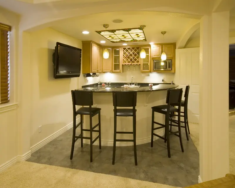 Basement wet bar with a curved granite counter and a lit stained-glass ceiling panel