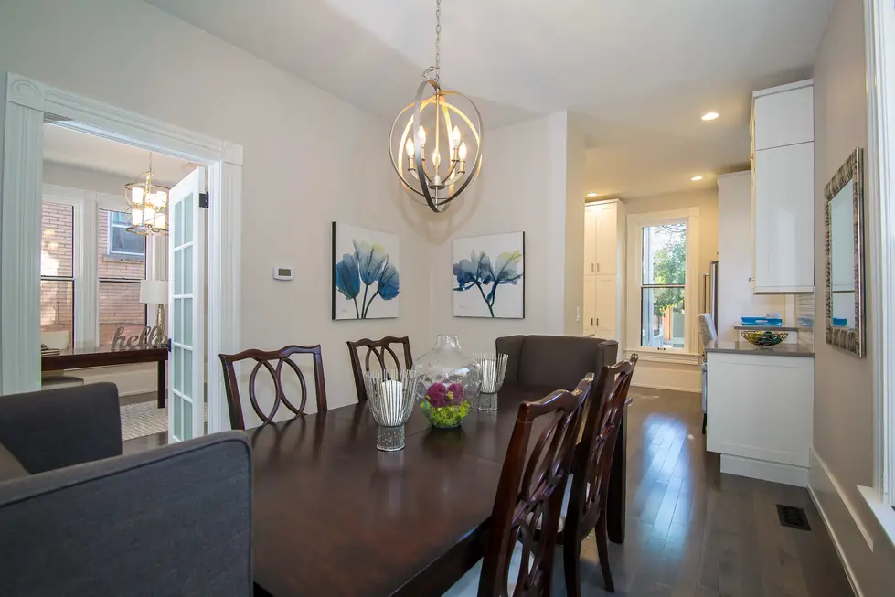Dining room under an orb chandelier, open through to the kitchen