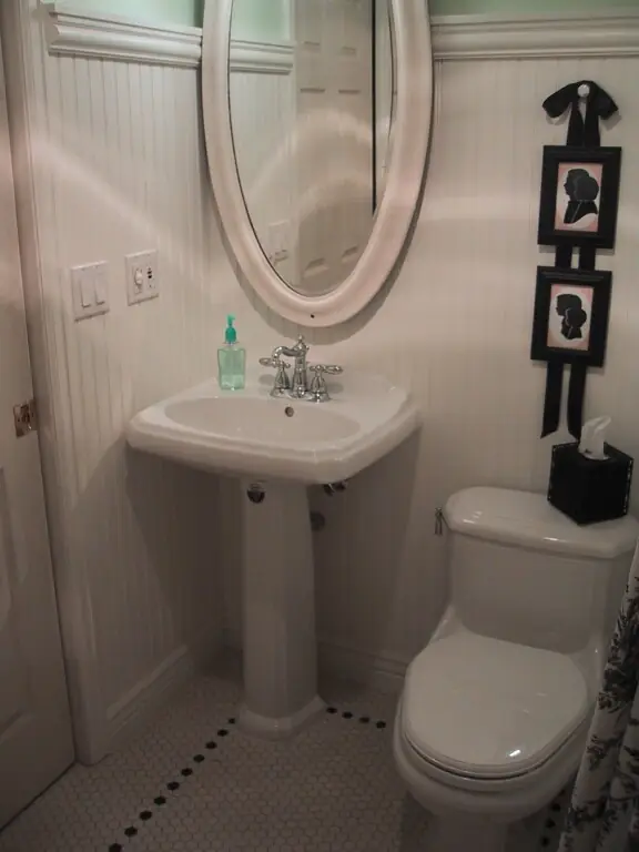 Powder room with a pedestal sink, beadboard wainscot and a mosaic tile floor